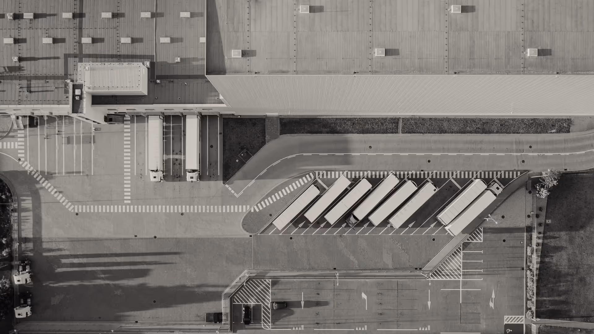 Aerial view of a warehouse loading dock with several trucks parked for loading and unloading.